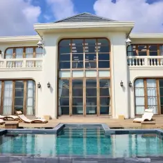 Luksusowy hotel paradise 8 z basenem i leżakami, otoczony zielenią i górami.